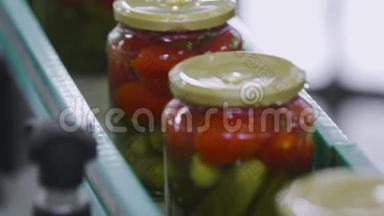 <strong>蔬菜加工</strong>自动生产线。 保存西红柿和黄瓜。 装有西红柿和黄瓜的玻璃瓶